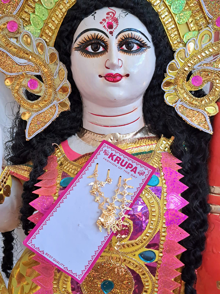 statue of sarsawati in colourful headdress with jewelry