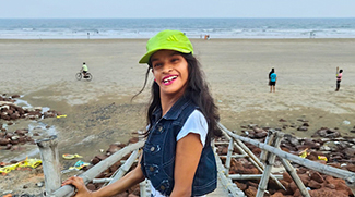 girl in green cap smiling on a pier near the sea