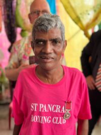 disabled man with gray hair wearing pink shirt
