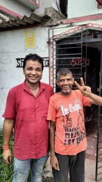 two men standing outside a house in Kolkata